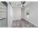 Bedroom featuring wood-look floors, a ceiling fan, a barn door closet and natural light from a large window at 14115 Nw 141St Ave, Williston, FL 32696