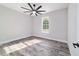 Bedroom with ceiling fan, wood-style tile, and light gray paint at 14115 Nw 141St Ave, Williston, FL 32696