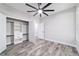 Bright bedroom featuring wood-look floors, a ceiling fan, and a large closet with built-in shelving at 14115 Nw 141St Ave, Williston, FL 32696