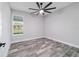 Bedroom featuring wood-look floors, a ceiling fan, and a large window providing natural light at 14115 Nw 141St Ave, Williston, FL 32696