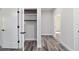 Walk-in closet with built-in shelving and ample storage space, complemented by stylish gray wood-look flooring at 14115 Nw 141St Ave, Williston, FL 32696