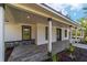 Inviting covered porch with stylish gray wood-look flooring and elegant white columns at 14115 Nw 141St Ave, Williston, FL 32696