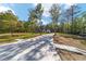 Long concrete driveway leading to a charming single-story home with mature trees surrounding the property on a sunny day at 14115 Nw 141St Ave, Williston, FL 32696