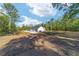 Beautiful single-story home with attached garage on a spacious lot surrounded by mature trees under a blue sky at 14115 Nw 141St Ave, Williston, FL 32696