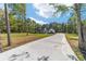 Inviting single-story home with a manicured front lawn and a long driveway leading to the residence with porch at 14115 Nw 141St Ave, Williston, FL 32696
