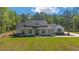 Beautifully landscaped front yard and covered porch on this charming single-story home with white and black trim at 14115 Nw 141St Ave, Williston, FL 32696