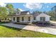 Stylish one-story home featuring a covered porch, dark-framed windows, and beautifully landscaped flowerbeds at 14115 Nw 141St Ave, Williston, FL 32696
