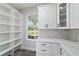Bright kitchen features white cabinets, quartz countertops, and open shelving near a window overlooking the yard at 14115 Nw 141St Ave, Williston, FL 32696