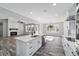 Open kitchen with view of living room fireplace, with white cabinets, quartz counters, and wood-look tile floors at 14115 Nw 141St Ave, Williston, FL 32696