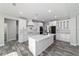 Spacious kitchen showcasing white cabinets, a large island, quartz countertops, and wood-look tile flooring at 14115 Nw 141St Ave, Williston, FL 32696