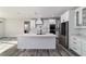 Open kitchen featuring white cabinets, a large island, stainless appliances, hardwood floors, and stone countertops at 14115 Nw 141St Ave, Williston, FL 32696