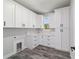 Well-lit laundry room featuring custom white cabinetry, white quartz countertops, and stylish gray wood-look tile flooring at 14115 Nw 141St Ave, Williston, FL 32696