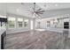 Bright living room with wood floors, a modern fan, and a view of the modern kitchen at 14115 Nw 141St Ave, Williston, FL 32696