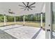 Covered patio with wood-look flooring, offering a serene view of the lush backyard and wooded area at 14115 Nw 141St Ave, Williston, FL 32696