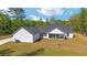 Back of house features a covered patio, grassy lawn, and trees at 14115 Nw 141St Ave, Williston, FL 32696