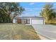 Ranch-style home with a two-car garage, nice landscaping, and a freshly-cut green lawn at 15854 Sw 38 Pl, Ocala, FL 34481