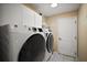 Bright laundry room featuring front loading washer and dryer with plenty of cabinet space at 16751 Se 84Th Colerain Cir, The Villages, FL 32162