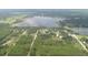 An aerial view displays a lake and properties of land covered with plenty of trees and scattered residences at 22764 Sw Sea Cliff Ave, Dunnellon, FL 34431