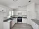 Bright kitchen with white cabinets, granite countertops, stainless steel appliances, and luxury vinyl plank flooring at 22764 Sw Sea Cliff Ave, Dunnellon, FL 34431