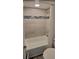 Modern bathroom featuring tiled shower with decorative mosaic stripe, white tub, and tiled walls at 2843 Ne 3Rd St # 109, Ocala, FL 34470