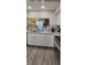 Modern kitchen with stainless steel appliances, granite countertops, white cabinets, and wood-look floors at 2843 Ne 3Rd St # 109, Ocala, FL 34470