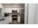 Modern kitchen featuring stainless steel appliances, white cabinets, and granite counters at 2843 Ne 3Rd St # 109, Ocala, FL 34470