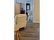 Cozy living room with hardwood floors, white cushioned recliner, and access to the kitchen at 2843 Ne 3Rd St # 109, Ocala, FL 34470