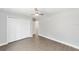 This bedroom is spacious and has wood-look flooring, closet, and ceiling fan at 4073 Se 136Th Pl, Summerfield, FL 34491