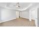 Large bedroom with tray ceilings, ceiling fan, and ensuite bathroom and walk-in closet at 4073 Se 136Th Pl, Summerfield, FL 34491