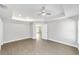 This primary bedroom features a ceiling fan, tray ceilings and an ensuite bathroom at 4073 Se 136Th Pl, Summerfield, FL 34491