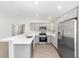 This kitchen boasts stainless steel appliances, gray cabinets, light counters and modern fixtures at 4073 Se 136Th Pl, Summerfield, FL 34491