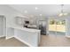 Bright kitchen features stainless appliances, a breakfast bar, gray cabinets, and access to the backyard through sliding glass doors at 4073 Se 136Th Pl, Summerfield, FL 34491