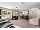 Inviting living room features a ceiling fan, large window, carpeted floor, and cozy furniture at 4243 Se 131St Ln, Belleview, FL 34420