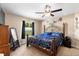 Comfortable primary bedroom with a ceiling fan, carpet floors, a window view to the backyard, and an en-suite bathroom at 4243 Se 131St Ln, Belleview, FL 34420