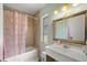 Bathroom featuring a shower-tub combo, large mirror and a vanity sink at 4410 Ne 13Th St, Ocala, FL 34470