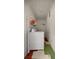 A compact laundry room with a washing machine and storage shelf at 4410 Ne 13Th St, Ocala, FL 34470