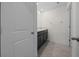 A view into the bathroom shows a modern vanity with dark cabinets and a tile floor at 4806 Sw 86Th Ln, Ocala, FL 34476