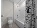 Bathroom with toilet, bathtub and shower behind a black and white patterned curtain at 4806 Sw 86Th Ln, Ocala, FL 34476