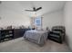 Relaxing bedroom featuring a ceiling fan, a comfortable queen-sized bed, and a gray accent chair at 4806 Sw 86Th Ln, Ocala, FL 34476