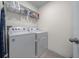 Practical laundry room equipped with a washer, dryer, shelving, and ironing board at 4806 Sw 86Th Ln, Ocala, FL 34476