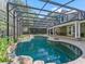 View of a large screened-in pool, covered patio, and spacious backyard at 6577 Nw 193Rd St, Micanopy, FL 32667
