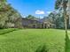 A spacious backyard showcasing a screen-enclosed pool, a lush lawn, and mature trees at 6577 Nw 193Rd St, Micanopy, FL 32667