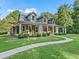 Beautiful home featuring a long porch, lush landscaping, and an inviting walkway at 6577 Nw 193Rd St, Micanopy, FL 32667