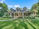 Inviting home with a covered porch, rocking chairs, and well-maintained lawn at 6577 Nw 193Rd St, Micanopy, FL 32667