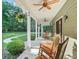 Covered front porch featuring ceiling fans, rocking chairs, and decorative hanging plants at 6577 Nw 193Rd St, Micanopy, FL 32667