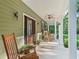 Relaxing front porch with rocking chairs, ceiling fans, and views of the manicured lawn at 6577 Nw 193Rd St, Micanopy, FL 32667