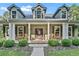 Charming front porch with rocking chairs, hanging plants, and a welcoming entryway at 6577 Nw 193Rd St, Micanopy, FL 32667