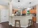 View of the kitchen with a breakfast bar, wood floors, and stainless steel refrigerator at 6577 Nw 193Rd St, Micanopy, FL 32667