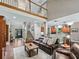 Living area with hardwood floors, a vaulted ceiling, a staircase and second-floor balcony at 6577 Nw 193Rd St, Micanopy, FL 32667