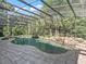 Stunning screened pool area with a rock waterfall feature and surrounding patio at 6577 Nw 193Rd St, Micanopy, FL 32667